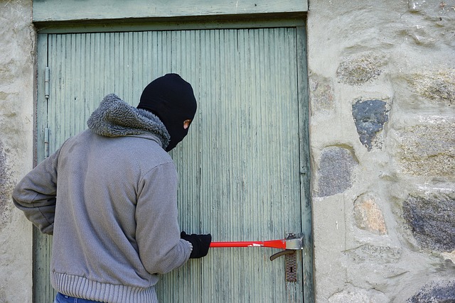 Cambrioleur tentant de forcer une porte, illustration de l'intérêt de simuler une présence pendant les vacances